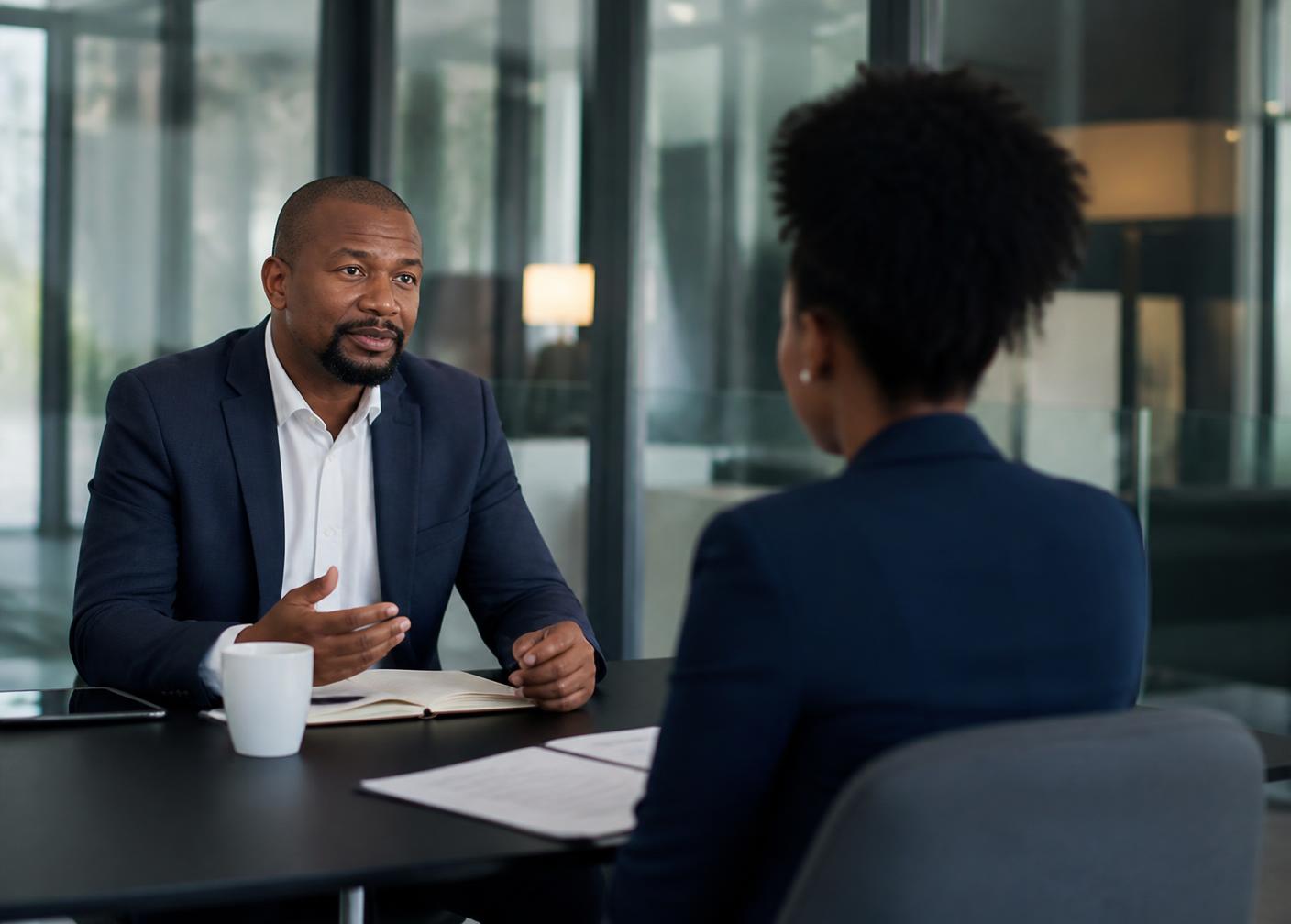 A hiring manager interviewing a candidate in a modern meeting room